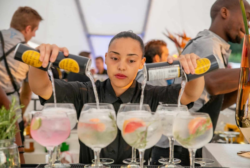 Bartender pouring drinks into glasses at a social event